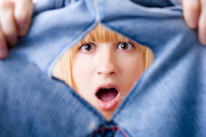 عکس یک دختر که به لباس پاره اش نگاه میکند
