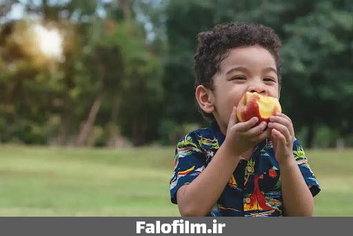 عکس یک کودک در حال خوردن میوه سیب