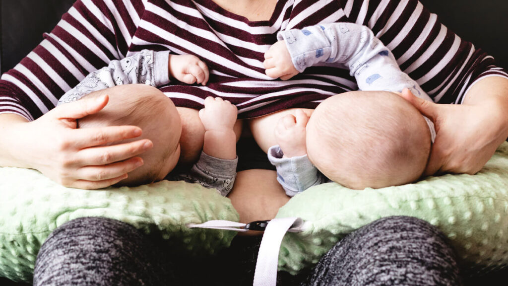 عکس یک زن در حال شیر دادن به دوقلوها