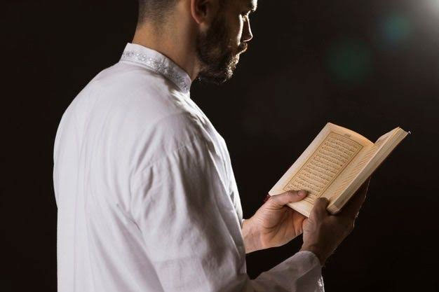 عکس یک مرد در حال خواندن قرآن