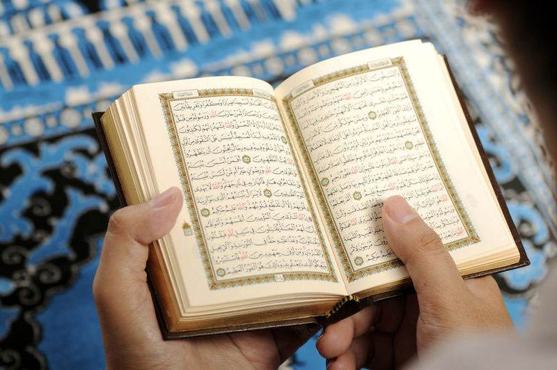 عکس از قرآن در دستان یک نفر